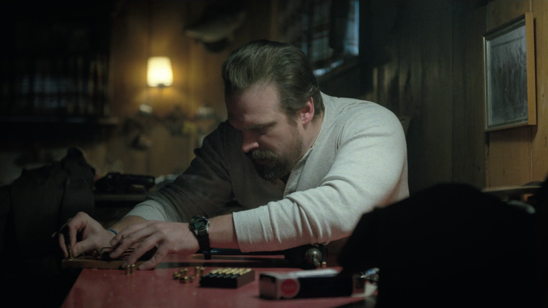 You can see the hair tie on Hopper’s right wrist as he creates the traps for the house.